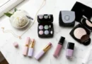 Delices Pastel De Chanel makeup flat lay with eyeshadow palette, illuminating powder, and lip products on white marble