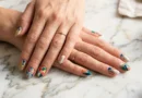 Colorful nail art designs featuring geometric patterns and glitter accents on well-manicured hands