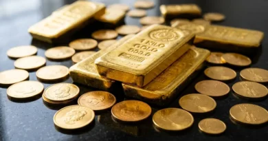 Gold bullion bars and coins on a dark reflective surface representing precious metals investment