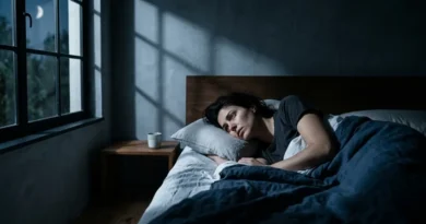 Restless sleep — person lying awake in dark bedroom unable to sleep with moonlight through window