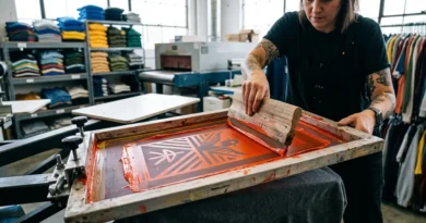 Screen printing mesh screen and squeegee applying vibrant ink to fabric in a fashion print shop